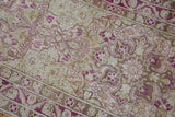 Angled view of meandering vine blossoms in dusty magenta on a distressed silver Yezd runner.