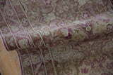 Folded vintage Yezd runner showing the distressed, low pile and magenta floral pattern.