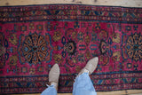 Vintage Persian Lilihan runner detail with raspberry field and sapphire motifs, with feet.