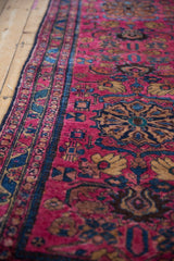 Hand-knotted Lilihan runner border showing raspberry red field and stylized blue animal motifs.