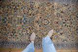 A perspective view of the dense pattern of palmettes and vines on a vintage tea-washed Persian runner.