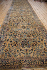 Low angle view of a vintage Meshed runner, emphasizing its long proportion and floral boteh design.