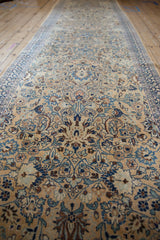 Long perspective view of the vintage runner's tea-washed, allover floral pattern.