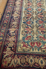 Ivory field of antique Kermanshah runner with vinery, blossoms, and stylized Samovar border motifs.