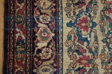 Antique Kermanshah rug close-up: cochineal red abrashes, dusty teal vinery, Samovar motifs.