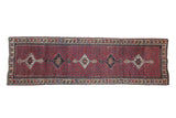 Vintage Kurdish runner featuring stepped medallions on a madder red field with a seed design.