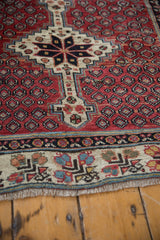 Geometric ivory border and stepped medallion on a hand-knotted vintage Kurdish runner with low pile.