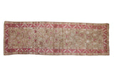 Distressed vintage Karabagh runner with raspberry botehs staggered over a neutral wheat field.