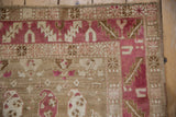 Serrated leaf border in raspberry red and distressed hand-knotted pile of a vintage Karabagh rug.