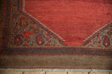Corner detail of a vintage Serab runner showing boteh motifs and the wide camel hair border.