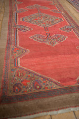 Side angle of a vintage Serab runner, detailing its geometric border and ram's horn finials.