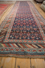 Kurdish runner's hand-knotted border with colorful striped bands and germinating plant pattern.