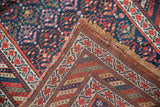 Vintage Kurdish runner detail: navy pile, colorful plant designs, and geometric flatweave reverse.