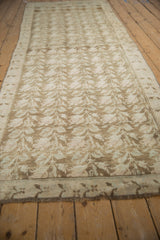 Distressed Karabagh runner with faded vertical vines and blossoms in soft tones.