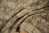 Close-up of distressed texture and faded vine pattern on a vintage Karabagh rug.