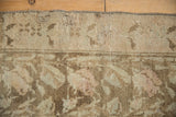 Secured edge and worn pile of distressed Karabagh runner, with faded vines in pale brown and ivory.