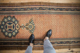 Distressed Hamadan runner with faded terracotta lattice field and patterned borders.