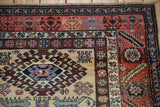 Vintage Northwest Persian runner detail: hooked medallion, serrated leaf border, rust, sand, and powder blue.