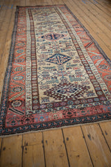 Northwest Persian runner detail: sand field, multi hook and latch medallions, colorful serrated leaf border.
