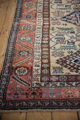 Navy blue serrated floral border and rust field with geometric hook and latch patterns.