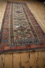 Vintage Northwest Persian runner end, rust serrated leaf border, geometric sand field.