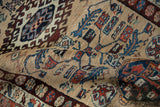 Textured pile of vintage Northwest Persian rug with sand, blue, rust hook-and-latch motifs.