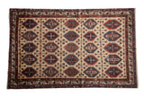 Vintage Northwest Persian carpet with a repeating panel motif in cherry red and navy blue on a dusty cream field.