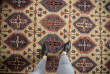 Worn low-pile texture of a Northwest Persian carpet with repeating panel motifs in red and navy.