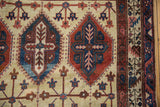 Close-up of the vintage carpet's panel design with inverted navy and cherry red geometric motifs.