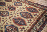 Angled view of the vintage Persian carpet showing the textured low pile and panel design.