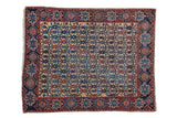 Antique Afshar rug with a dense floral lattice pattern in dusty navy, red, and saffron.