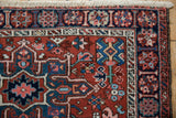 Corner of a vintage Karaja rug highlighting the pomegranate border, hand-knotted texture, and ivory fringe.