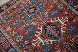 Serrated floral blossoms and geometric relief in the hand-knotted pile of a vintage Karaja rug.