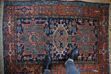 Vintage Karaja rug showcasing geometric starburst florals and turtle border in terra cotta, navy.