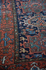 Vintage Persian Karaja rug detail with terracotta geometric starbursts and navy turtle border.