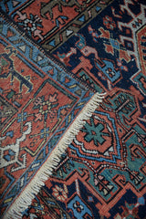 Fringe, terra cotta field, and geometric navy turtle samovar border of a vintage Karaja rug.