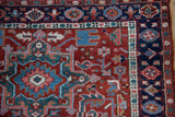 Vintage Karaja rug detail: cherry red field, navy border, geometric blossoms, serrated leaves.