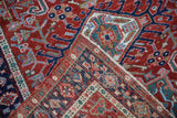 Folded vintage Karaja rug corner revealing hand-knotted back and cherry red pile.