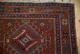 Karaja rug upper corner showing starburst floral border and blue diamond medallion motif.