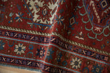 Finely woven details of the Karaja rug's deep red field with blue and ivory motifs, folded.