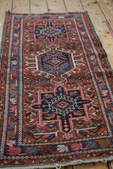 Vintage Karaja rug's geometric medallion and border; brick red, navy, sky blue palette.