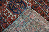 Folded vintage Karaja rug corner, showing foundation weave and minor tatter.