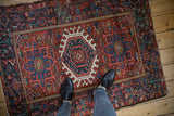 Vintage Karaja rug, triple hook and latch medallion in cherry red and navy, with feet.