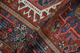 Folded vintage Karaja rug, showing cherry red and navy blue hook and latch motifs.