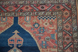 Vintage Malayer rug corner: dusty navy spandrel, madder red field with bird, and intricate borders.
