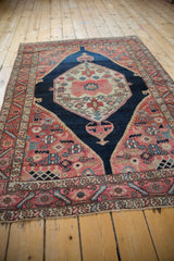 Vintage Malayer rug corner with madder red field, stylized birds, and vine border.