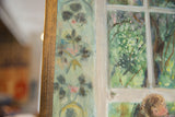 Textured canvas detail: painting's teal border and green window scene with wood frame.