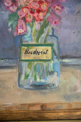Yellow label with dark script on painted vase and wood frame edge.