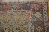 Corner of antique Kurdish Bijar rug, ochre yellow henna plant design field, dark brown border.