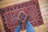 Vintage Karaja rug corner with cherry red starburst main border and polychromatic selvage.